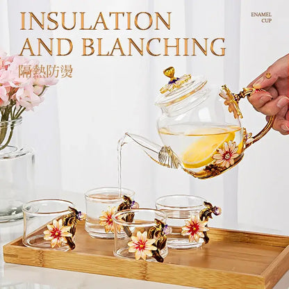 Clear glass teapot set with gold enamel floral decorations and matching crystal glass cups for dining room use