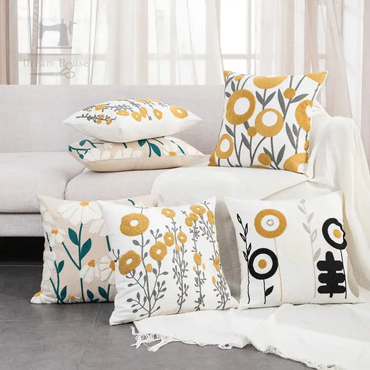 A collection of decorbites daisy floral geometric embroidery throw pillows in yellow black green and white on soft fabric