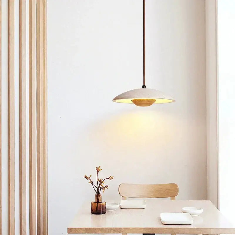 Minimalist danish cream stone wood chandelier with matte off-white disc shade and warm golden interior glow for bedroom décorbites cream stone