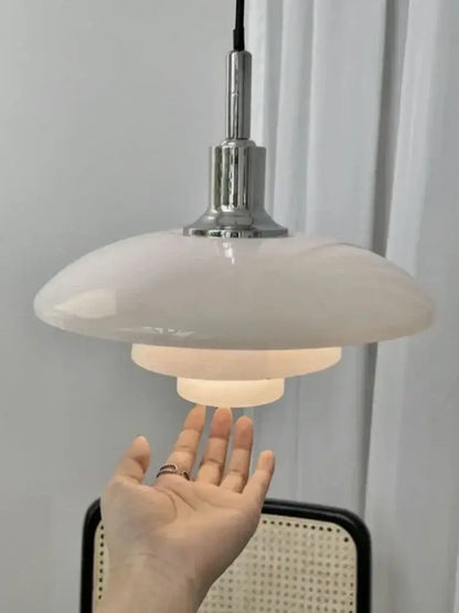 A sleek modern pendant light with glossy white glass shade and chrome hardware as a focal point for dining rooms