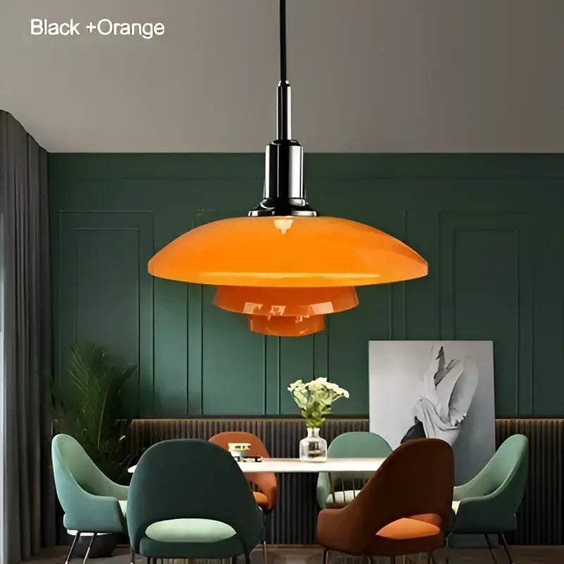 Orange glass pendant light with black metal hardware as a focal point in a Danish tiered frosted glass dining fixture
