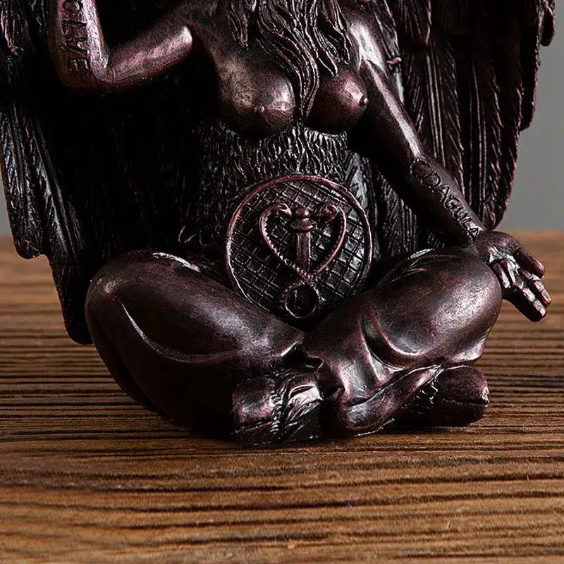 Dark bronze baphomet resin statue depicting a winged demon with long hair seated in meditation over a skull for gothic decor