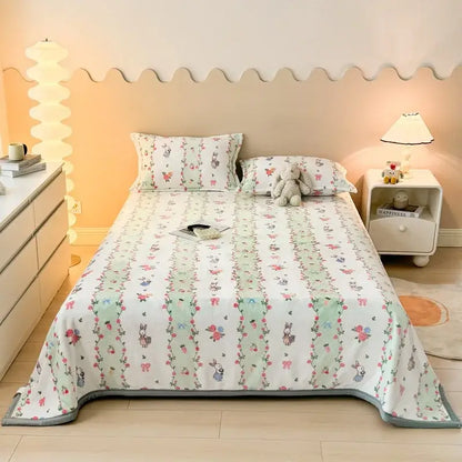 Dark gray cartoon print flannel sofa cover with soft white bedspread featuring pastel green stripes bunnies and pink flowers decorbites cartoon print