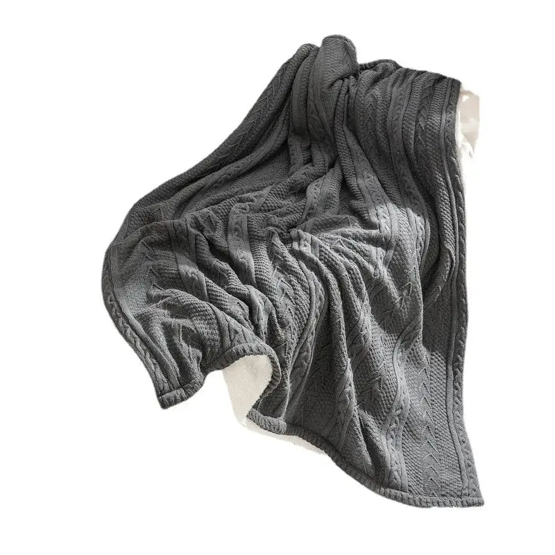 A dark gray fishbone knit blanket with white fleece lining featuring a cozy double layer decorbites cozy double design