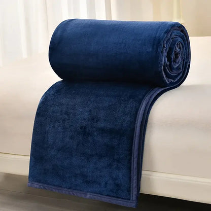 A plush navy blue fleece blanket rolled neatly on white surface from decorbites cozy flannel living room sofa cover