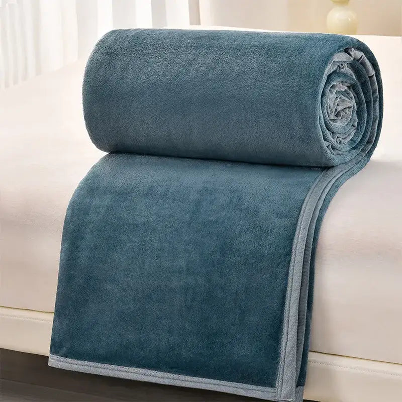 A decorbites cozy flannel blanket in teal with a light gray border rolled on a white surface for living room decor