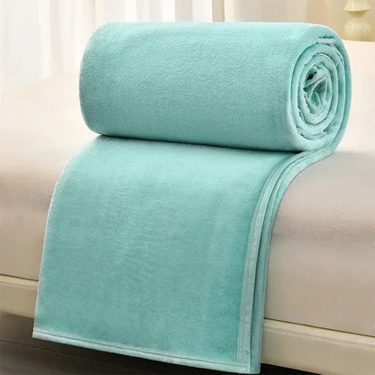 A soft light blue fleece blanket rolled over a bed edge paired with dark gray and light gray cozy flannel blanket decorbites cozy flannel