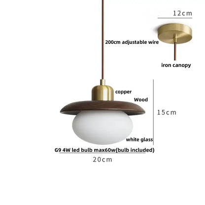 A dark wood and brass finished glass led pendant lamp with an oval white glass bulb for dining room lighting