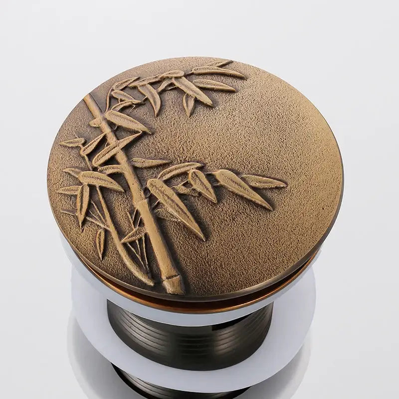 Bronze decorative tree motif pop-up drain cover with embossed bamboo leaf design for bathroom sink decorbites brass bathroom