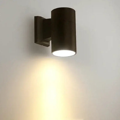 Dark bronze cylindrical 10w light wall sconce with sleek modern design casting warm light downward for outdoor use