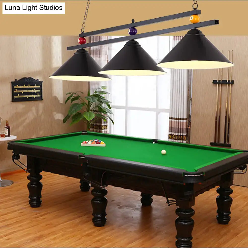 Decorbites™ 3-head conical metallic billiard light in black red and blue hanging above a black wrought iron pool table with green felt surface and ornate legs
