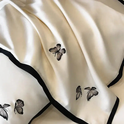 Cream-colored silk scarf with delicate black butterfly embroidery and border complementing 600TC Egyptian cotton bedding set