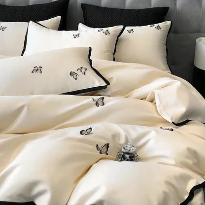 Cream-colored satin 600tc egyptian cotton bedding set with black butterfly embroidery and contrasting black piping