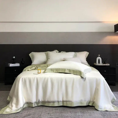 Elegant ivory satin decorbites™ 600tc lyocell eucalyptus fiber bedding set with sage green piping on a modern bed