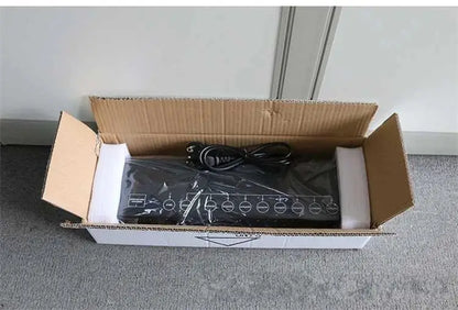 Black DecorBites™ 8-port DMX signal amplifier splitter wrapped in plastic inside cardboard box showing back side ports