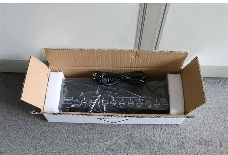 Black DecorBites™ 8-port DMX signal amplifier splitter wrapped in plastic inside cardboard box showing back side ports