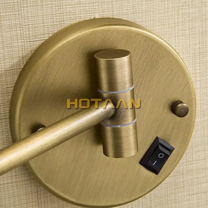 Antique brass-finished wall-mounted reading lamp with adjustable arm and black switch next to decorbites™ round led light makeup mirror