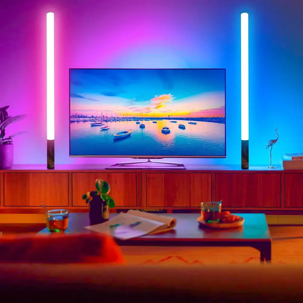 A sleek modern flat-screen tv showing a vibrant sunset paired with decorbites 85cm color-changing mood lighting sticks with music mode for home party and bar