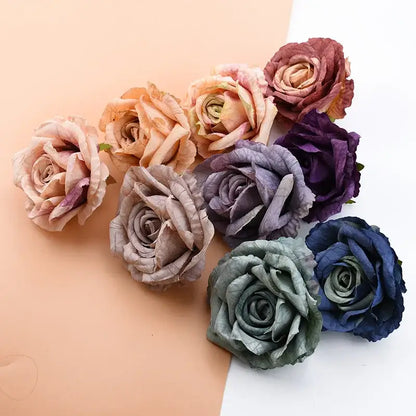 A collection of DecorBites™ 9cm silk roses artificial flowers in muted dusty rose, lavender, deep purple, and navy blue tones