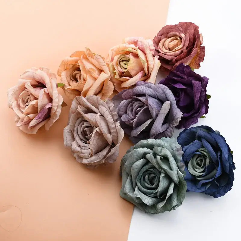 A collection of DecorBites™ 9cm silk roses artificial flowers in muted dusty rose, lavender, deep purple, and navy blue tones