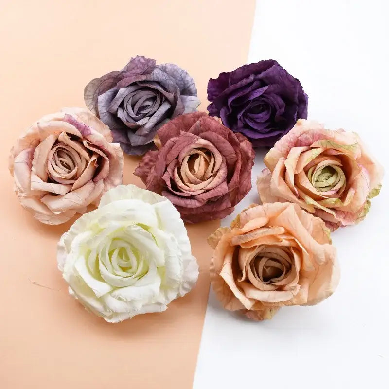 A collection of six decorbites 9cm silk roses artificial flowers in soft pastel and deep purple hues made from textured fabric