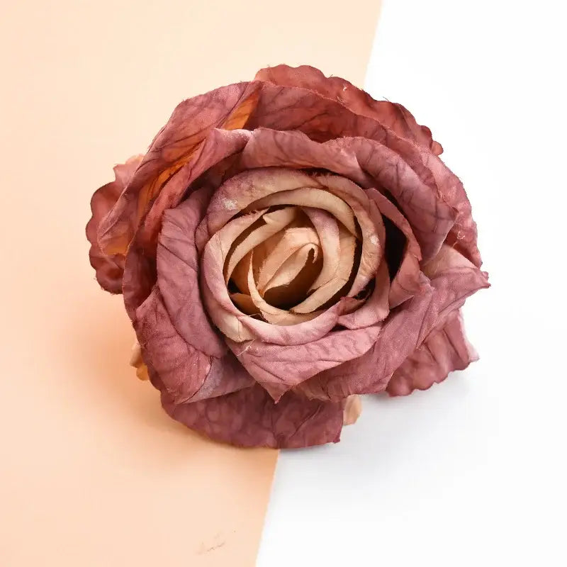 A dried dusty pink and mauve layered rose made of textured fabric in decorbites™ 9cm silk roses artificial flowers