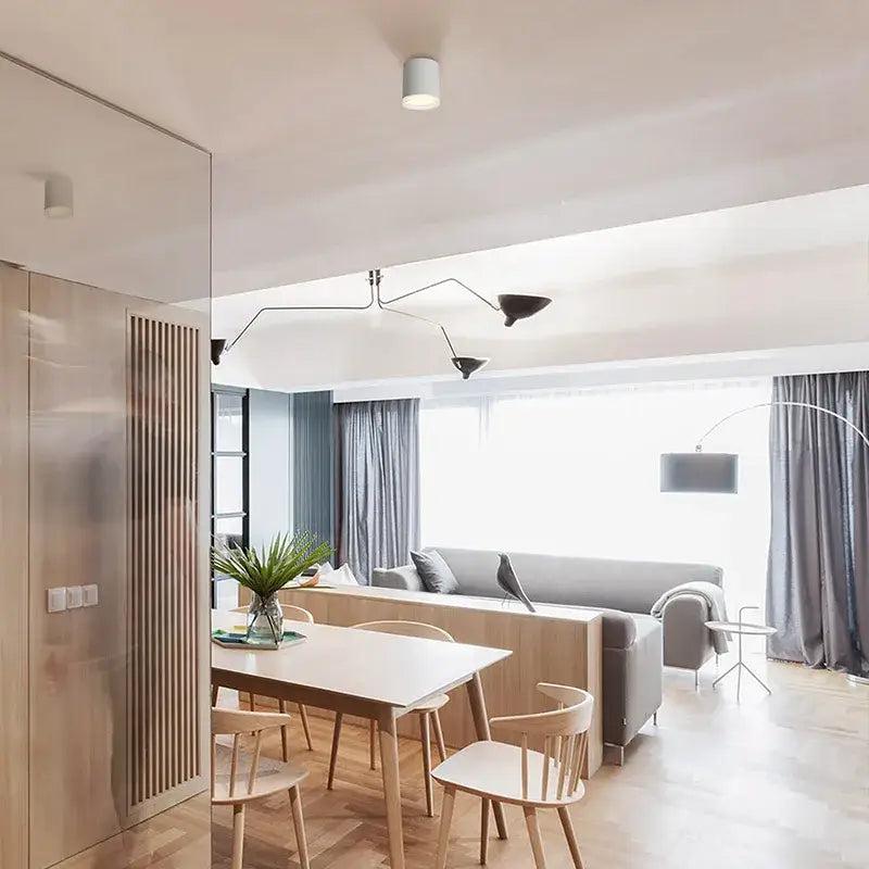 Modern minimalist dining table with light wood finish and slender legs illuminated by decorbites 9w cri97 anti-glare led downlight