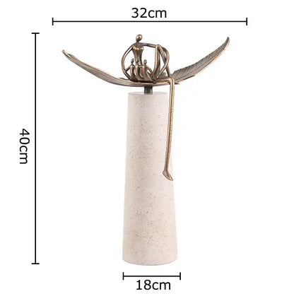 Bronze-colored abstract character marble sculpture with outstretched wings on textured off-white base for room decor