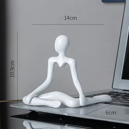 White glossy resin decorbites abstract figures ornament sculpture depicting a stylized human in meditation pose