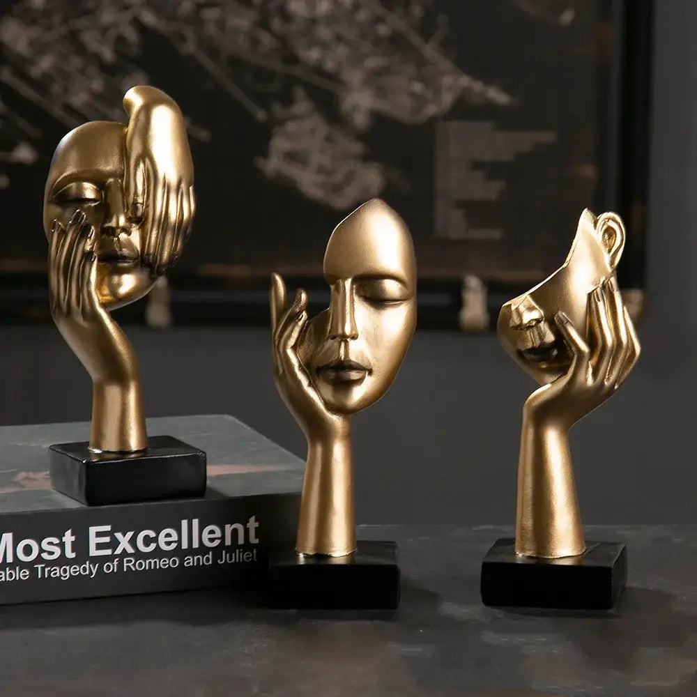Three golden resin decorbites abstract figurines with hands on faces mounted on black bases for modern home decor