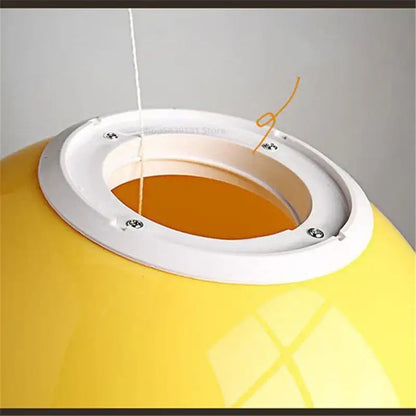 Bright yellow acrylic balloon ceiling light with orange interior and white mounting ring for modern living room decor