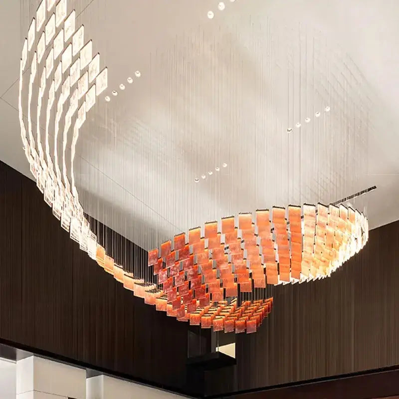 A modern curved acrylic chandelier lights with translucent orange and white rectangular panels for home lighting