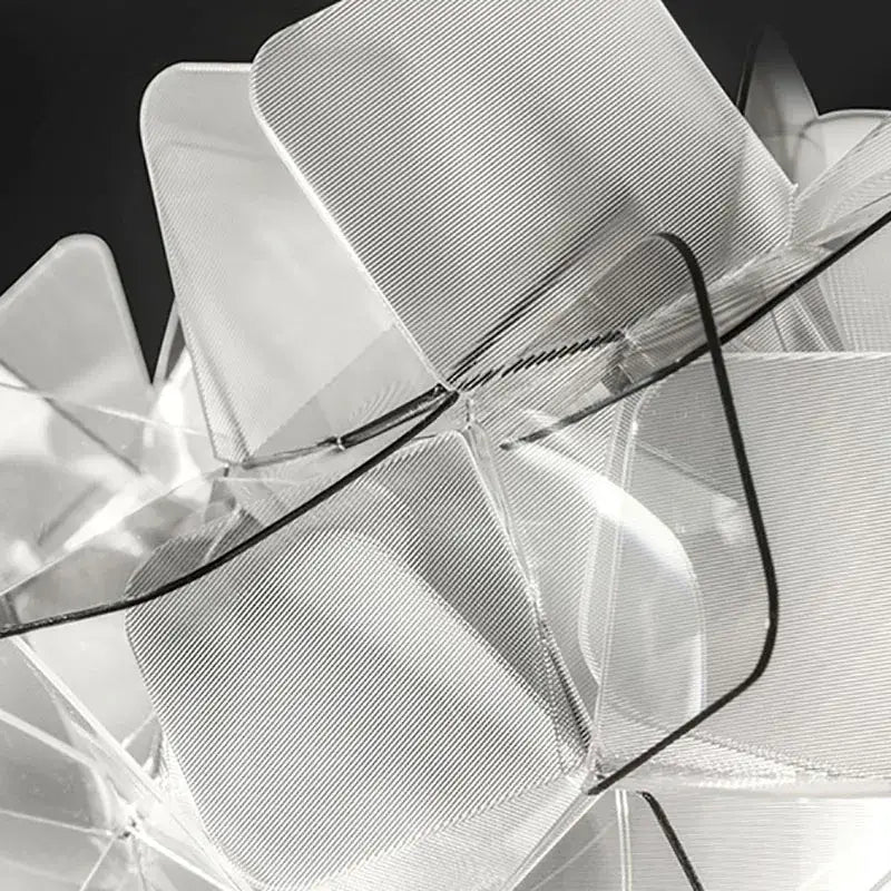 Transparent acrylic chair with geometric layered design and black accents paired with decorbites acrylic flower led table lamp
