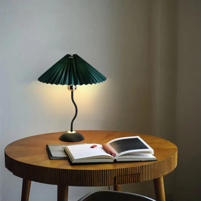 Decorbites adjustable pleated table lamp with dark green fabric shade, black curved metal base, and gold-toned accents
