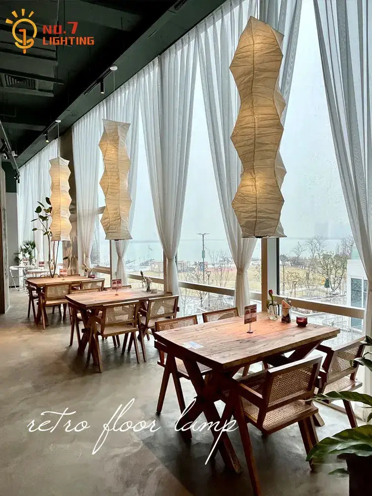Tall cream-colored akari noguchi rice paper floor lamp with wavy segmented design for living room lighting