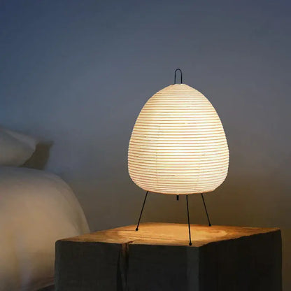 Elegant off-white DecorBites Akari Noguchi table lamp with rice paper shade, slender black metal legs, and curved handle for décor