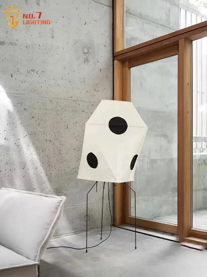 White geometric decorbites akari rice paper floor light with black accents and slender metal legs in minimalist design