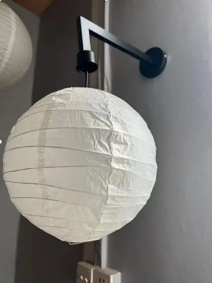 White spherical akari rice paper pendant lamp with black metal wall mount for living room and bedroom decor