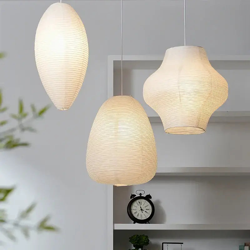 Three elegant off-white akari rice paper pendant lamps with ribbed texture and soft glow for living room and bedroom decor