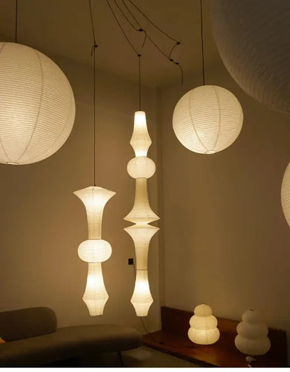 White paper akari rice paper pendant lamps in various sizes and shapes with textured segmented design for living room