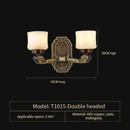 Antique brass-finished double-headed wall sconce with frosted glass shades and ornate details for luxury copper marble jade lighting