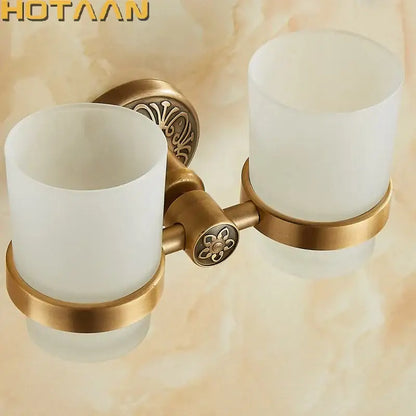 Decorbites aluminium double tumbler holder in antique brass finish with frosted glass cups and ornate floral detailing