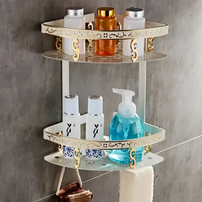 Gold-toned aluminum bath hardware set corner shelf with mirrored surfaces and decorative scrollwork for bathroom organization
