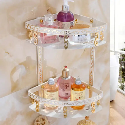 White and gold ornate aluminum bathroom corner shelf with glass shelves holding toiletries in antique finish