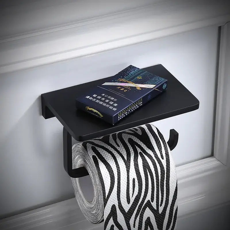 Black matte aluminum bathroom paper holder with phone holder wall mount featuring zebra-striped tissue roll
