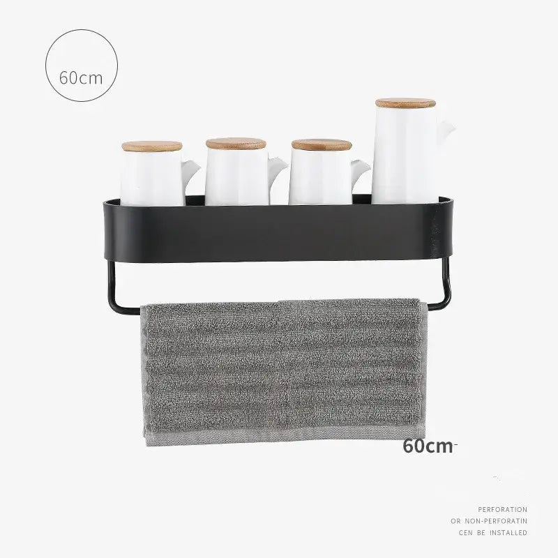Black metal wall-mounted bathroom shelf with aluminum towel bar and four white ceramic mugs with wooden lids for organization