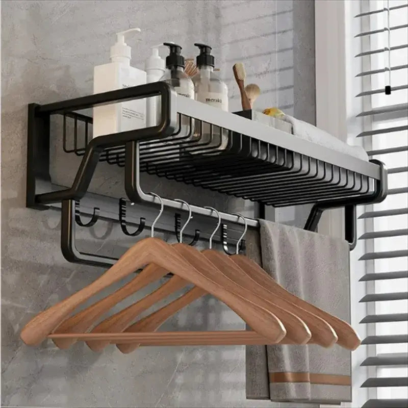 Black metal aluminum bathroom towel holder with wire mesh storage basket and integrated hooks holding wooden hangers