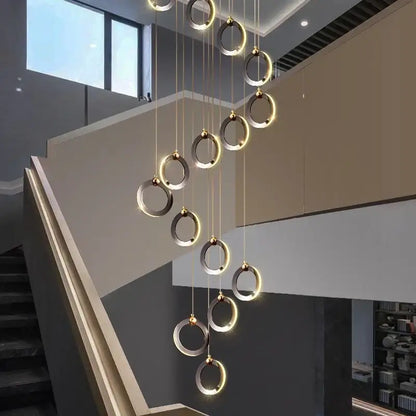 Modern minimalist aluminum led chandelier with brushed gold and matte silver rings emitting warm ambient glow