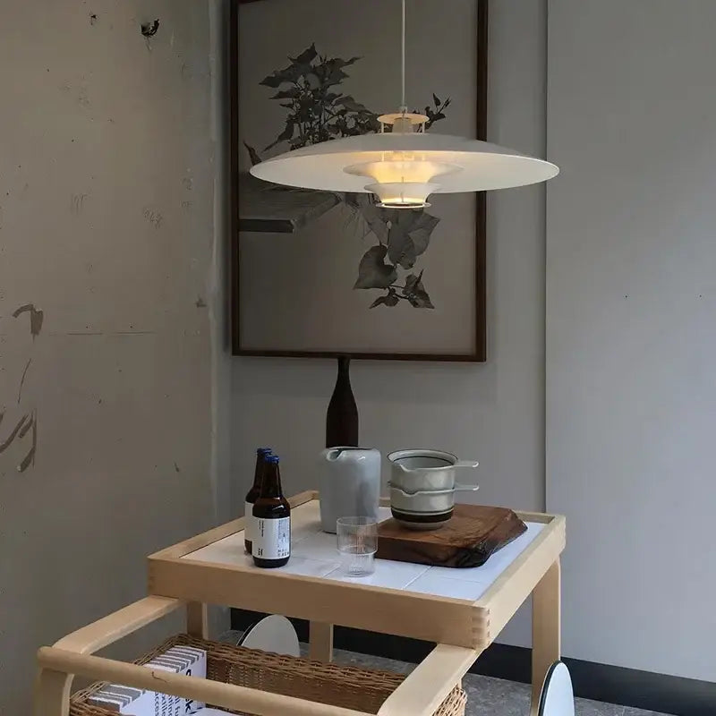 A modern white decorbites aluminum pendant light with sleek circular design and warm glow for kitchen island lighting