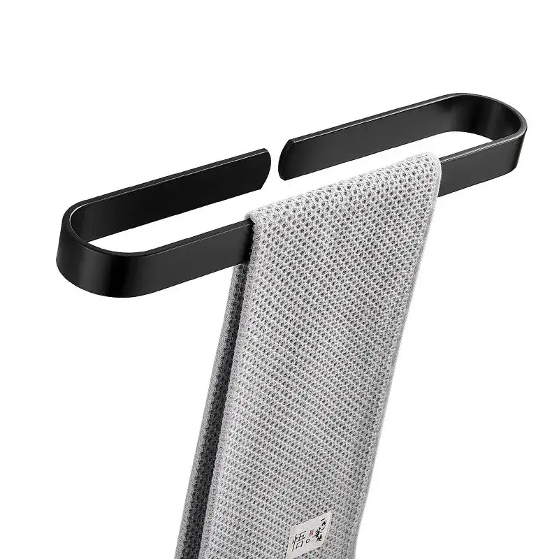 Decorbites aluminum towel holder matte black wall mounted towel bar holding a gray textured towel